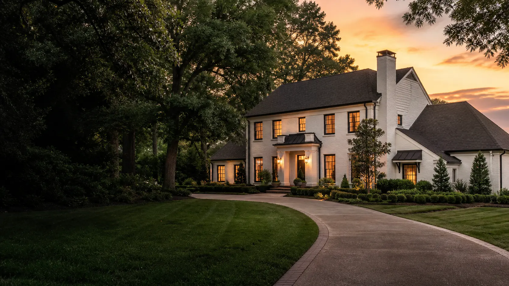 Representative premium Alabama residence at dusk with mature trees and a landscaped lawn